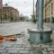 Stalen grondpot verzonken in Europees kasseienstraatwerk met verkeersbordpaal vergrendeld in de pot en bouwgereedschap op de grijze bestrating.